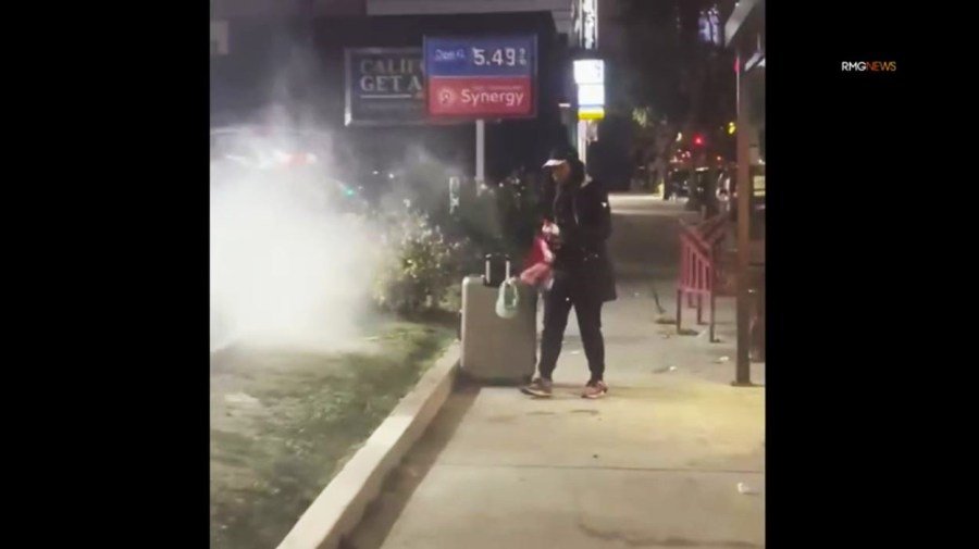 Un transeúnte con un extintor interviene cuando el sospechoso prendió fuego a un automóvil en una gasolinera de Hollywood el 27 de diciembre de 2024. (RMG)